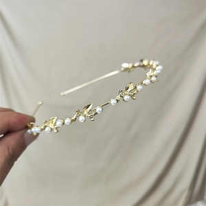 Slim gold alloy headband featuring white faux pearls and delicate golden leaf branch accents