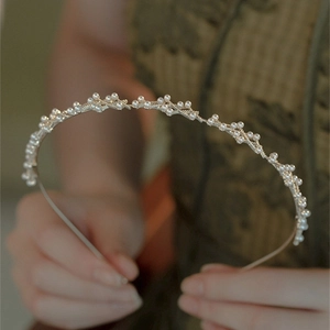 Elegante cerchietto in metallo dorato con perle bianche dal delicato design a vite per donna