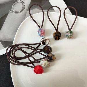 Detail showing elastic hair ties with tulip-shaped beads in marble and floral patterns