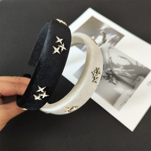 Detail of padded satin headbands in black and gold with sparkling star rhinestones