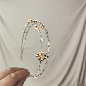 Detail of a golden double-layered floral headband with rhinestones and hollow flowers