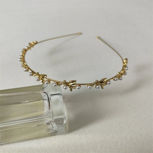Detailed shot of golden leaf headband with pearls on a textured background