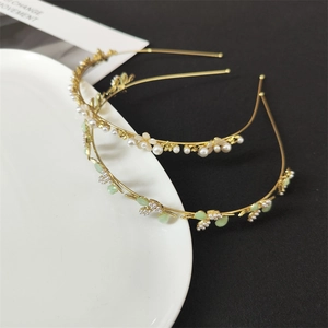 Detail view of gold alloy floral headband with cat eye stones and pearls