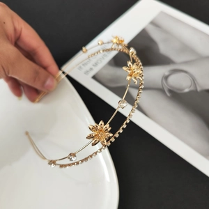 Double-layered gold headband featuring rhinestone floral ornaments for elegant styling