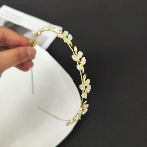 Detail of golden flower leaf headband with cat eye stones and pearls for hair styling
