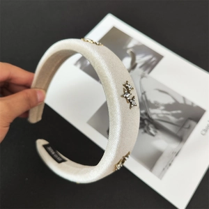 Detail of champagne satin padded headband featuring star rhinestones and handmade label