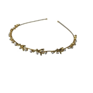 Elegant gold metal headband featuring white pearls and delicate leaf design on white background