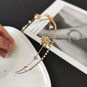 Detailed macro view of golden dual-layer flower headband with sparkling rhinestones and zircons