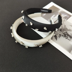 Close-up of handmade satin padded headbands with sparkling rhinestones in black and champagne