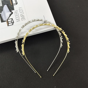 Dettaglio di cerchietti sottili in metallo color oro e argento con piccole perline