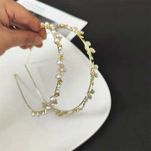 Detail of floral hairbands featuring cat eye stones and pearls on golden alloy base