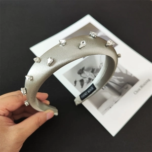 Close-up of handmade silver satin sponge headband with sparkling white rhinestones