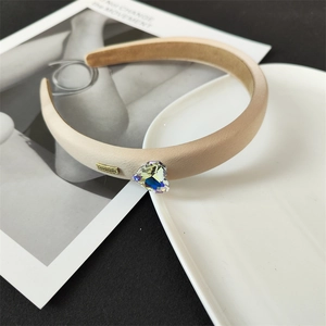 Détail du serre-tête en satin champagne avec cristal de cœur et plaque en métal doré Lovedays