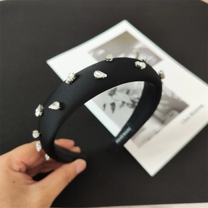 Detail of black sponge headband with sparkling rhinestones and handmade inner mark