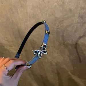 Handmade blue denim headband with a vintage metal butterfly and dark gemstone detail