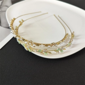 Close-up of golden flower and leaf headband set with pearls and cat-eye stones