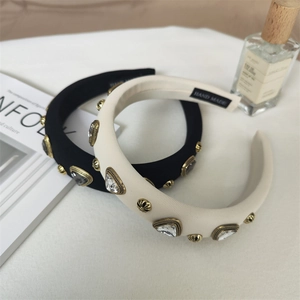 Detail of vintage padded headband with gold relief studs and crystals on soft satin