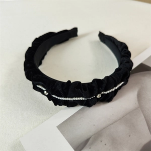 Detail of vintage black pleated velvet headband with pearls and sparkling rhinestones