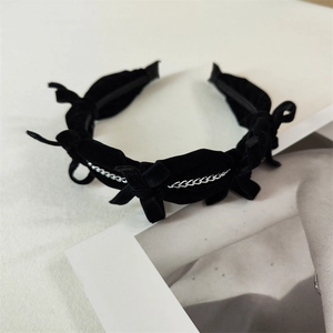 Detailed close-up of vintage black velvet headband with silver chain and bow accents