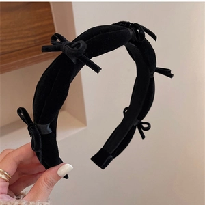 Close-up of vintage black velvet headband featuring cute bows and thick padded design