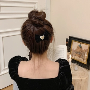 Détail d'un nœud à cheveux en velours noir avec strass cœur sur les cheveux