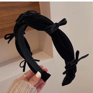 Close-up of vintage black velvet headband featuring multiple mini bow decorations
