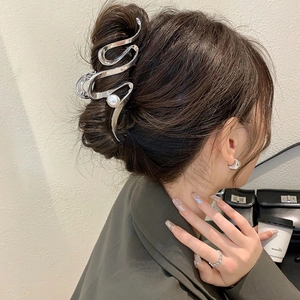 Pince à cheveux métallique argentée au design ondulé épuré et détail de perle blanche