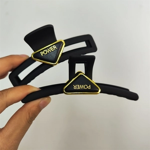Matte black large shark hair claw clip with golden triangle Power logo accent