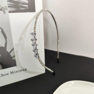 Elegant thin silver headband featuring sparkling rhinestones and triangle-cut crystals