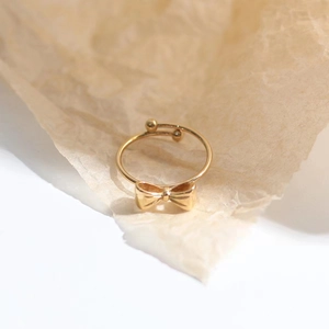 Detailansicht eines goldenen, verstellbaren Schleifenrings mit kleinen Metallperlen