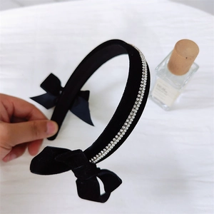 Close-up of vintage black velvet headband featuring dual bows and delicate rhinestone trim