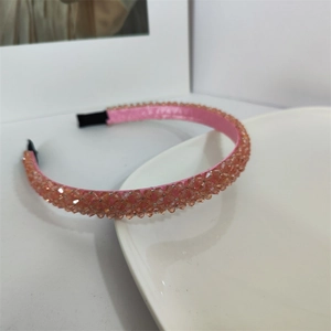 Détail d'un serre-tête rose perlé avec doublure en satin et embouts antidérapants