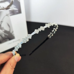 Detail view of shimmering zircon crystals on elegant wavy silver headband accessory
