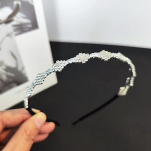 Detailed macro view of crystal zircons and floral rhinestones on silver hairband