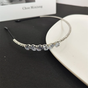 Detailed macro view of the sparkling crystal rhinestones on a slim silver metal headband