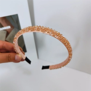 Gros plan détaillé des perles de cristal champagne sur un bandeau en soie rose protecteur