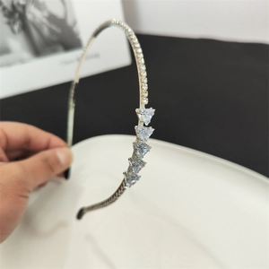 Detail view of silver thin headband with pavé rhinestones and five triangle crystal accents