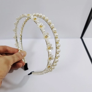 Detail of double-layer white floral headband with faux pearls and rhinestone accents