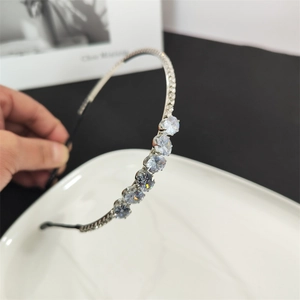Macro shot of silver thin headband with six large round zircons and small rhinestones