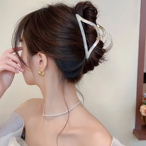 Detailed view of large marbled acetate triangle hair claw clip on model hair