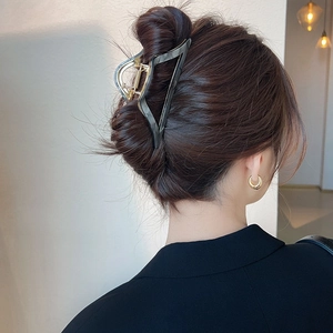 Detail of dark grey transparent triangle hair claw clip on long brunette hair bun