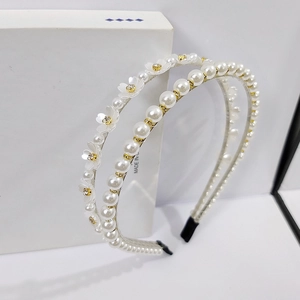 Detail of double-layer headband with white flowers and artificial pearls on gold metal frame