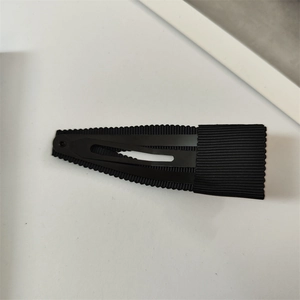Détail de la pince à cheveux en ruban gros-grain noir avec texture côtelée et métal