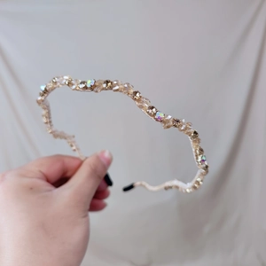 Close-up of wavy crystal headband with champagne gold finish and sparkling rhinestones