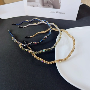 Close-up of handmade wavy crystal headbands with sparkling rhinestones and woven details
