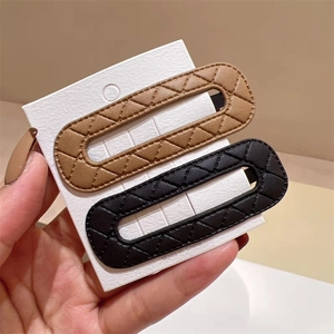 Quilted leather BB hair clips in brown and black set on minimalist white display card