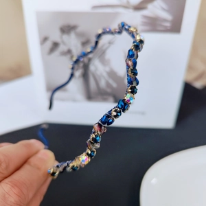 Detailed close-up of handmade crystal beaded wave headband with shimmering blue stones