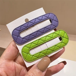 Quilted leather snap hair clips in purple and bright green on white display card
