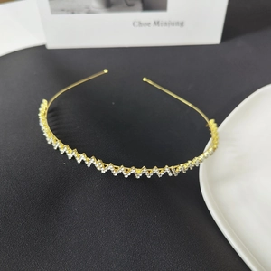 Elegant thin gold metal headband with sparkling wave pattern rhinestones on black background