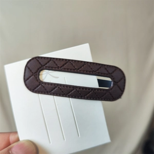 Close-up of a dark brown quilted PU leather BB hair clip with hollow oval design